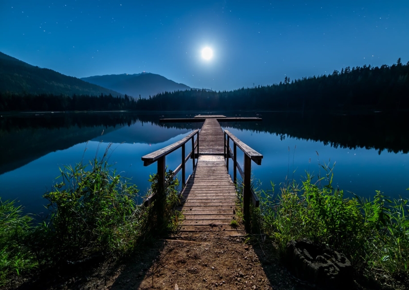 Wooden dock on a lake in the moonlight
